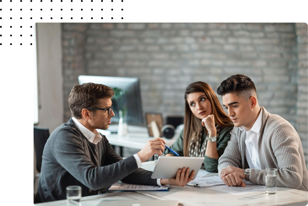 Sales consultant presenting strategy to clients using a tablet in a business meeting